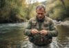 Équipement essentiel pour les sorties de pêche : focus sur la veste de pêche Homme pêcheur en veste technique au bord de la rivière